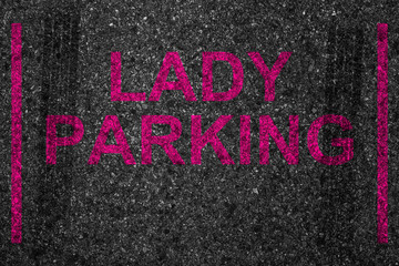 reserved car park slot with paint text word lady parking, woman driver driving stop space