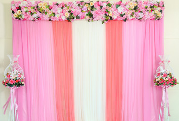 backdrop of fake flowers with pink and white fabric arrangement