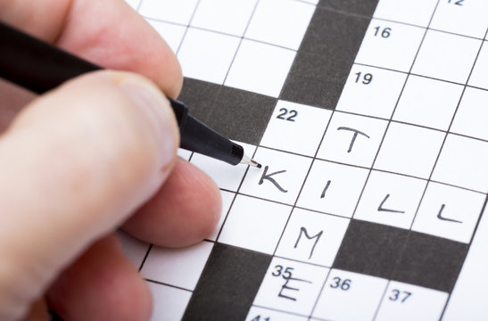 A Person Is Doing A Crossword Puzzle. The Words Kill And Time Is Written On It. Good Training For Brains For Elderly People And Stress Relieve. Focus Point On The Pen Tip.