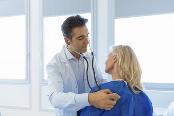 Doctor examining senior patient in hospital