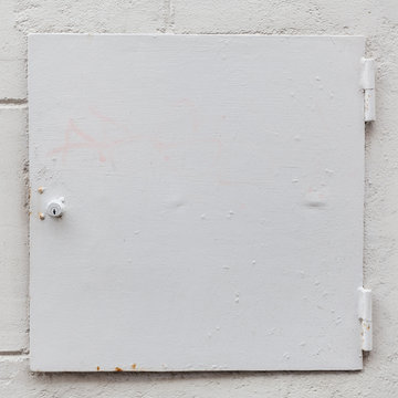 White steel safe in white wall.