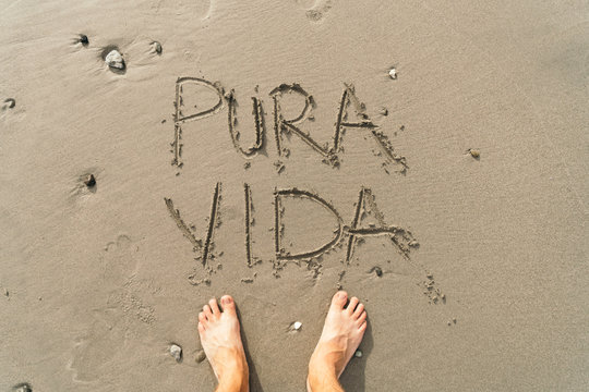 Pura Vida message on the beach sand