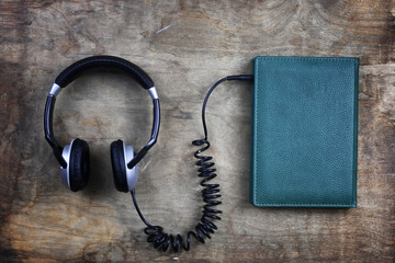 audiobook headphones and book on wooden table