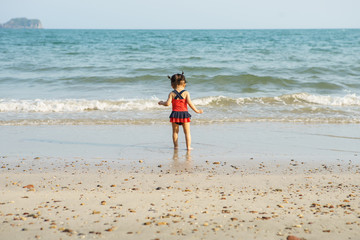 Adorable little girl at tropical white sand beach