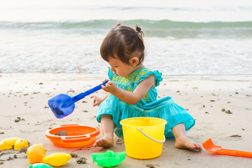 Little girl playing with beach toys during tropical vacation