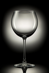 Empty wine glass on a color background.
