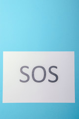 Word SOS written on paper