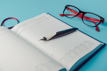 notebook on blue paper. open diary and pen to record