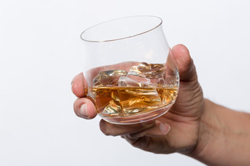 Hand hält Whiskeyglas mit Whiskey auf Eis