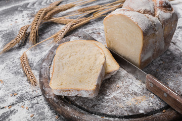 Bakery concept background. Knife cutting bread loaf slices