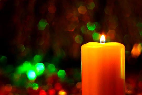 Christmas and New Year`s  evening burning candle  Retro style greeting card background with holiday tinsel and lights.