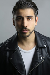 young man wearing a black leather jacket over a white background