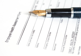 close up employee health assessment form and pen