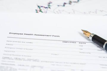 close up employee health assessment form and pen