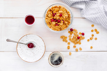 flakes in bowl with berries on wooden background top view