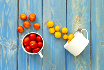 Different colored tomatoes on a blue wooden background