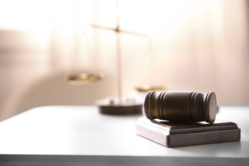 Judges gavel and justice scales on table in the room