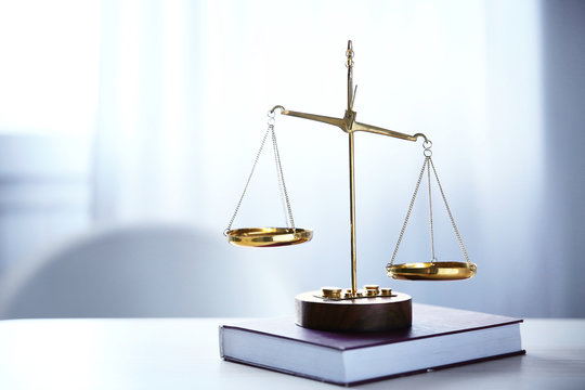 Justice scales and book on table in the room