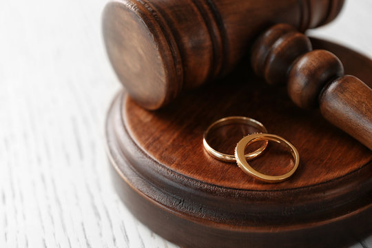 Golden wedding rings with judge gavel, closeup