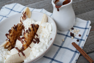 banana split with ice cream, chocolate, whipped cream and waffles. classic yummy baby dessert.