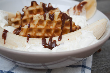 banana split with ice cream, chocolate, whipped cream and waffles. classic yummy baby dessert.