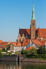 Fototapeta premium Wroclaw city, view from embankment on odra river and tumski island and catholic Church of the Holy Cross and St. Bartholomew. Famous touristic polish postcard view