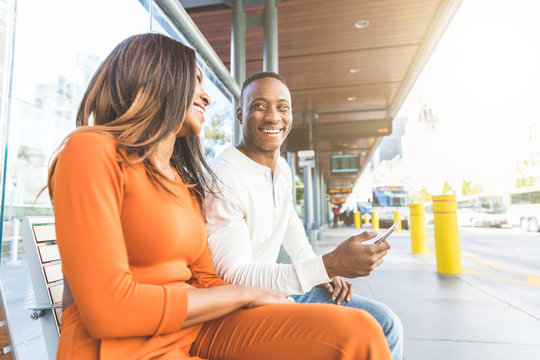 Black couple waiting for the bus at station