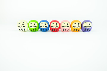 Colorful Daruma dolls on white background. (Daruma doll is a lucky charm of Japan. Write the eye when the wish come true.)