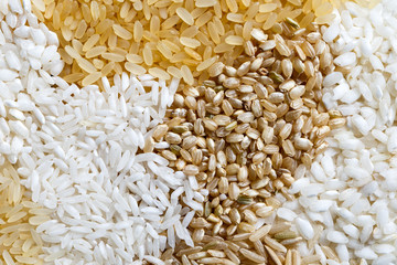 Abstract pattern made of white, brown and parboiled rice from above.