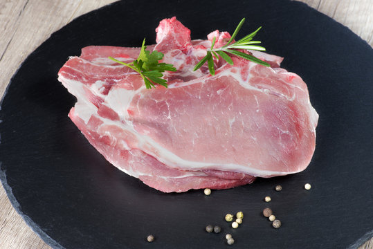 c&ocirc;telette de porc crues sur ardoise