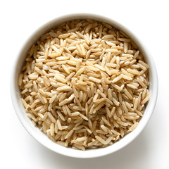 Bowl of long grain brown rice isolated on white from above.