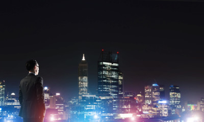 Businessman viewing night glowing city
