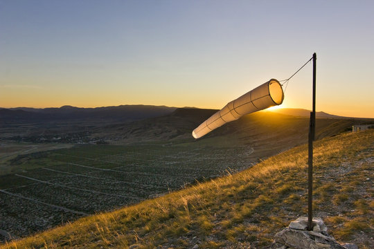 windsock at sunset in mountains against sun