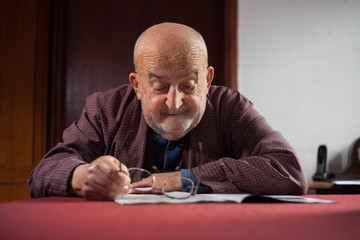 old man in pajamas reading newspaper