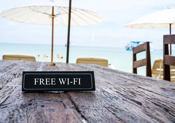 Free Wi-Fi banner on restaurant table, beach background