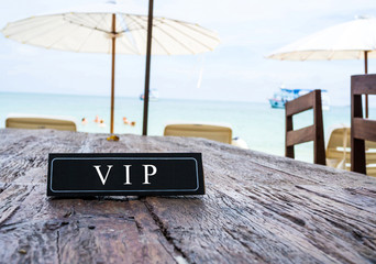 VIP banner on restaurant table, beach background