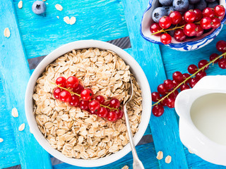 Rolled oats and berries on blue textured background. Top view