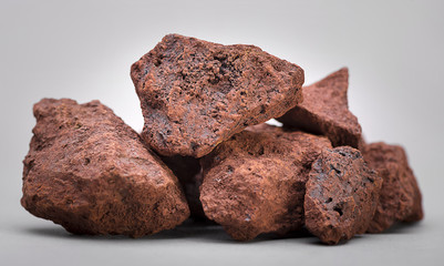 Heap of natural iron ore over gray background.