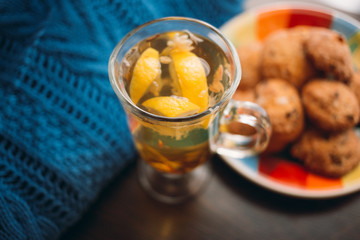 Autumn Still Life: Herbal tea on a wooden table near the window. The sun's rays on a cup of brewed tea. A cup of hot chayas pichenem on a sunny day on the background of the window. Autumn tea