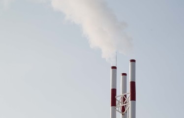 industrial smoke from chimney on blue sky

