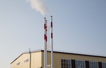 industrial smoke from chimney on blue sky
