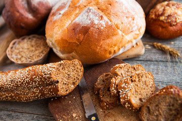 Fresh bread slice and cutting knife on rustic table