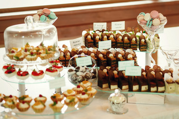 Pieces of chocolate cakes and sweet baskets stand on the plates