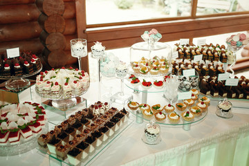 Tasty chocolate and cheese cakes stand on the glass dishes on wh