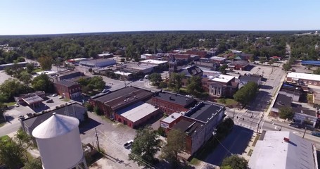 Aerial of a small town with downtown and water tower in view.