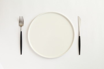 Knife, fork and plate isolated on white background