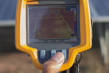 electrician working on  maintenance equipment at industry solar power;  engineer use IR camera to check temperature loss of solar panel 