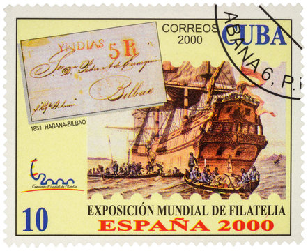 Ancient sailing ship and boats with sailors on postage stamp