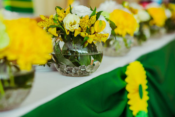 Festive table decorated with yellow and white flowers