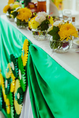 Festive table decorated with yellow and white flowers